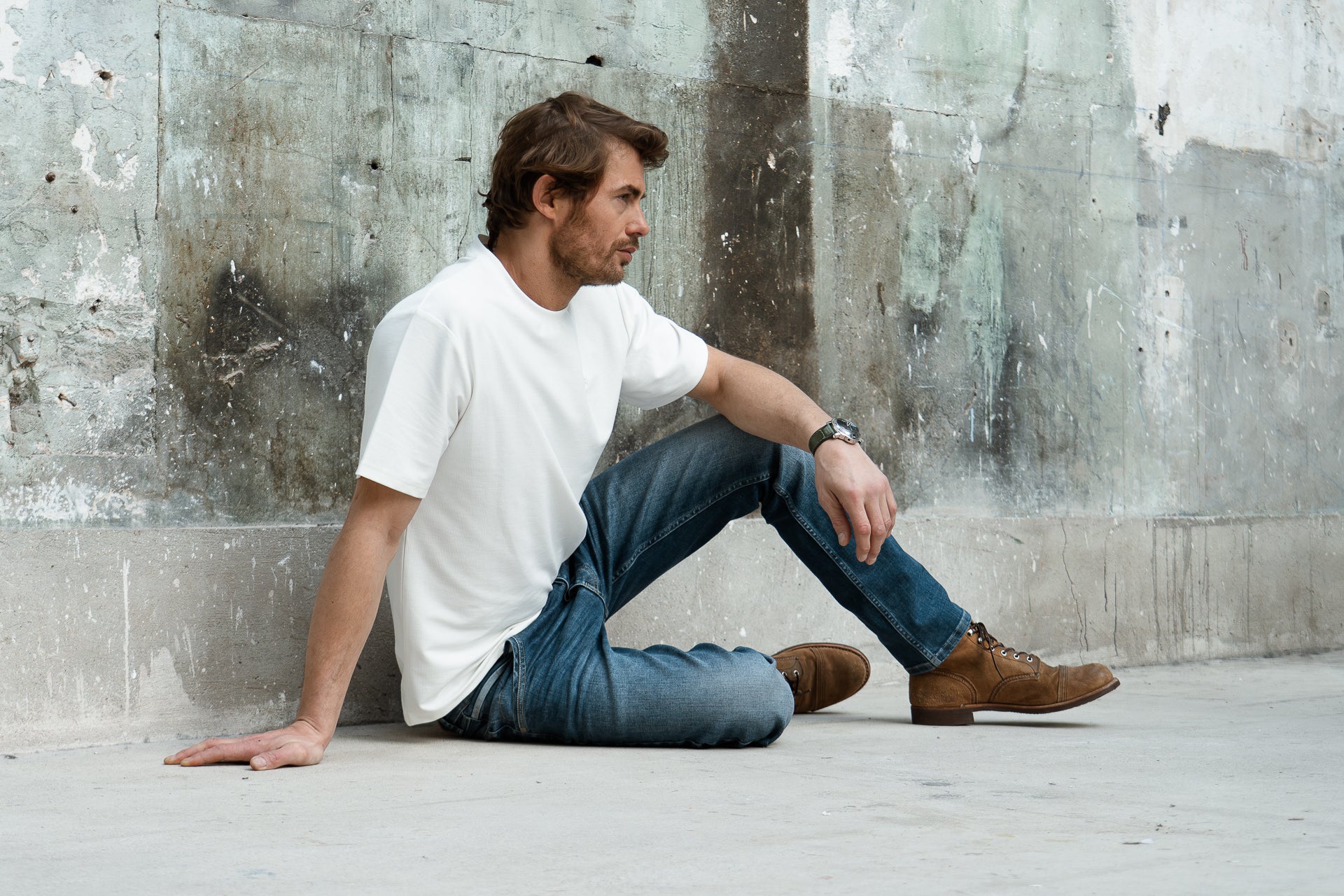 homme assis avec un t-shirt blanc et un jeans