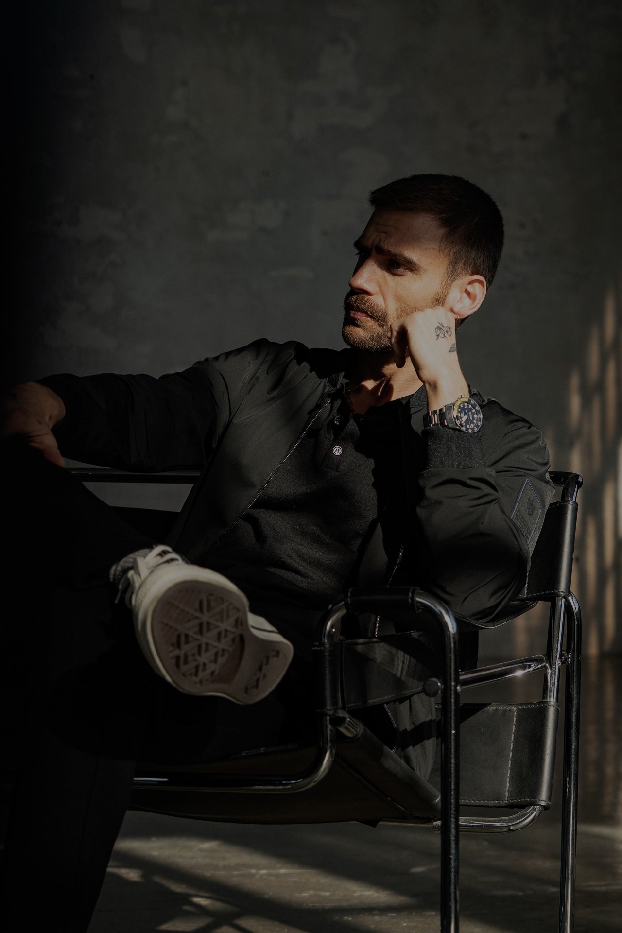 home avec un polo et un bomber noir