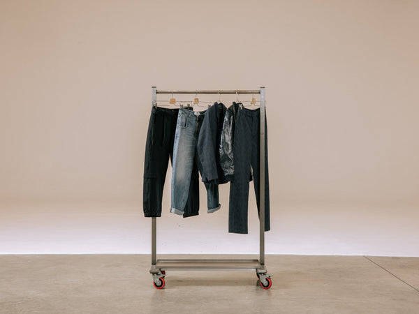 Un portant avec différents vêtements en denim accrochés dessus